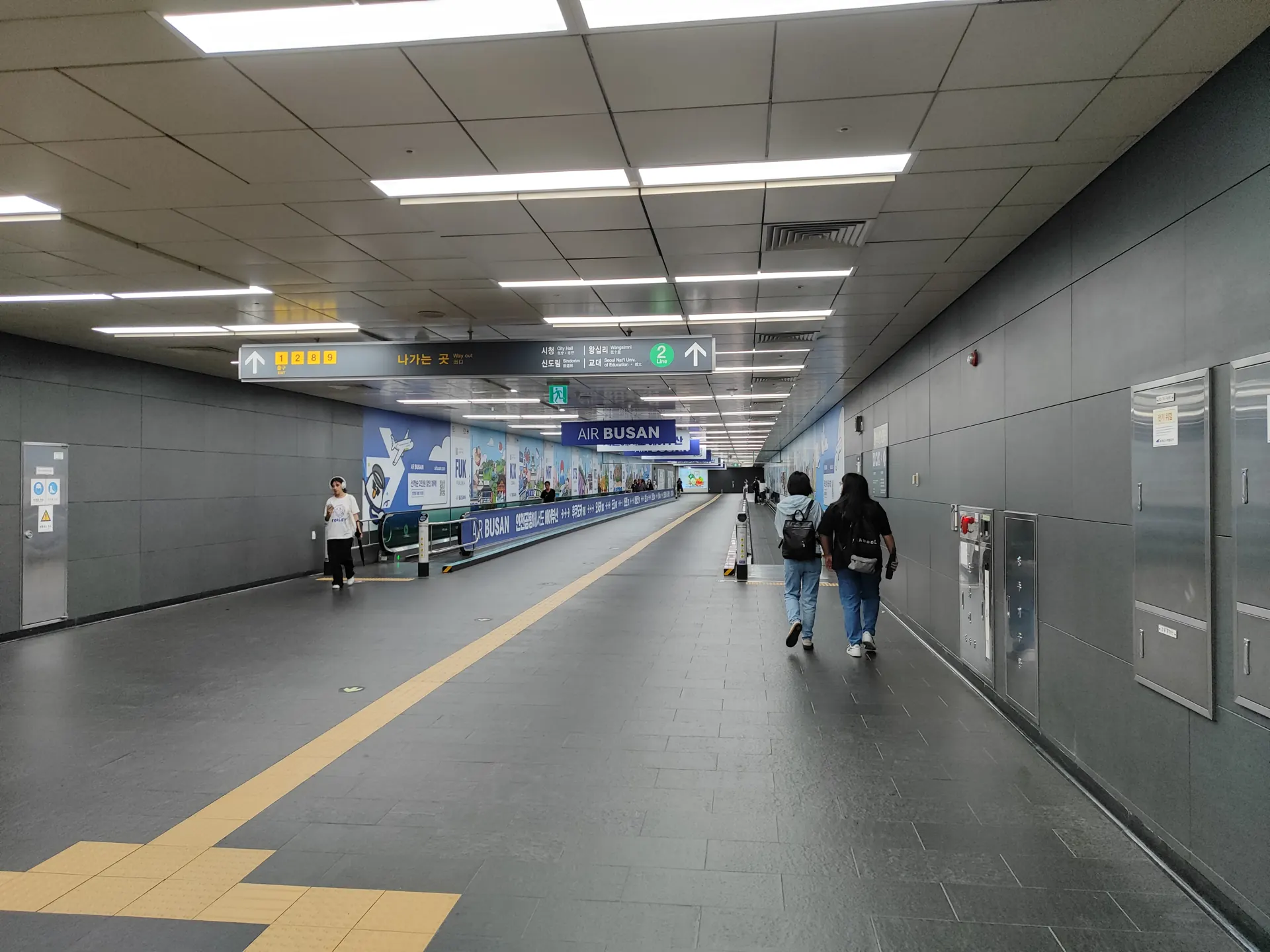 Green 2 + direction arrow, above the moving walkway