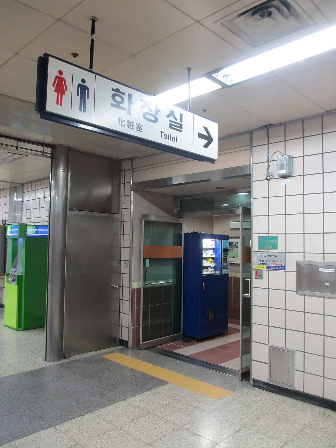 Señal de aseos en una estación. Busca el pictograma de aseos en estaciones, terminales, parques y edificios públicos.